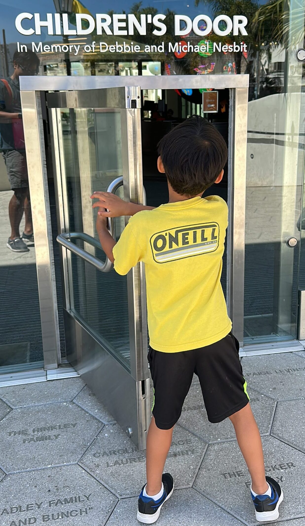 Child standing in front of the mini children’s door at the Moxi Children’s Museum